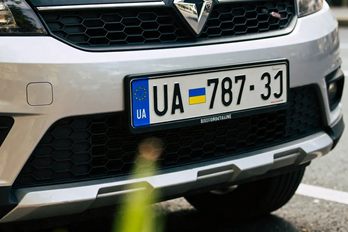 Plaque d'immatriculation UA sur voiture argentée garée en extérieur sur une route