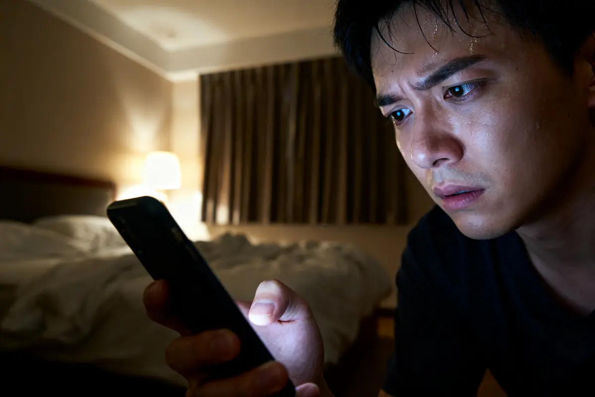 Homme inquiet consulte résultat du permis à 1h du matin sur son téléphone