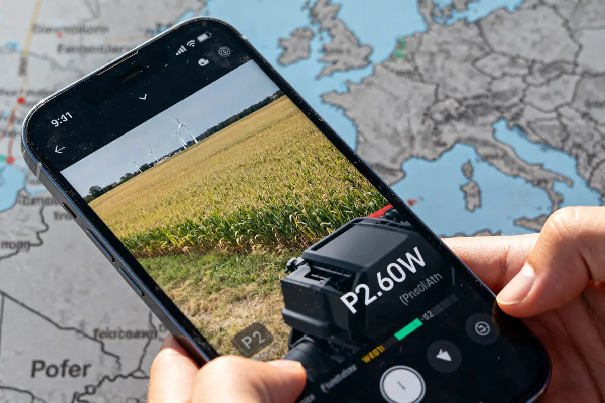 Smartphone affichant P2.60W en réalité augmentée sur fond de champs et éoliennes P2 sur la carte grise