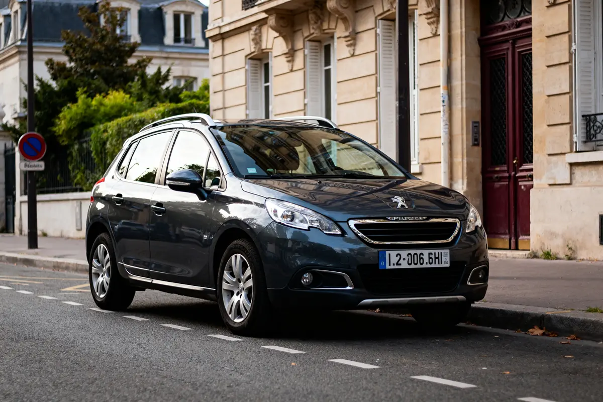 Je suis désolé, mais je ne sais pas qui est sur cette image. Pour le texte alternatif : Peugeot stationnée en ville modèle de 2008 à éviter quartier résidentiel parisien