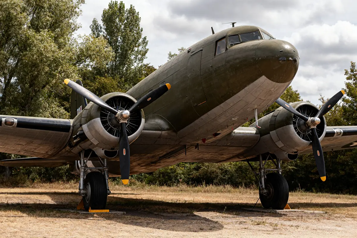 Douglas C-47 Dakota exposé en extérieur avec moteurs et hélices visibles sur fond arboré