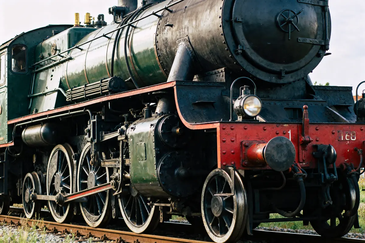 Gros plan sur une ancienne locomotive à vapeur, roues et détails métalliques visibles