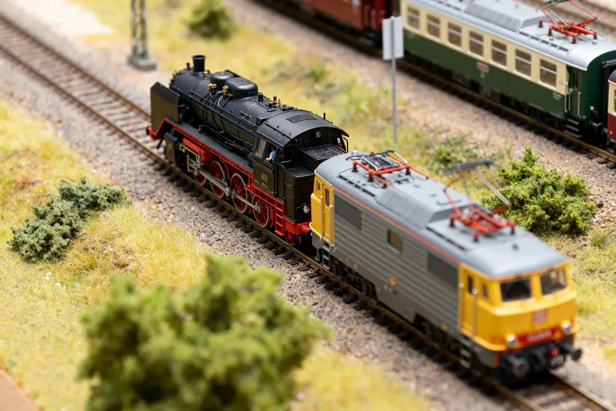 Modèles réduits de trains avec locomotive HO noire et jaune sur voie paysagée réaliste
