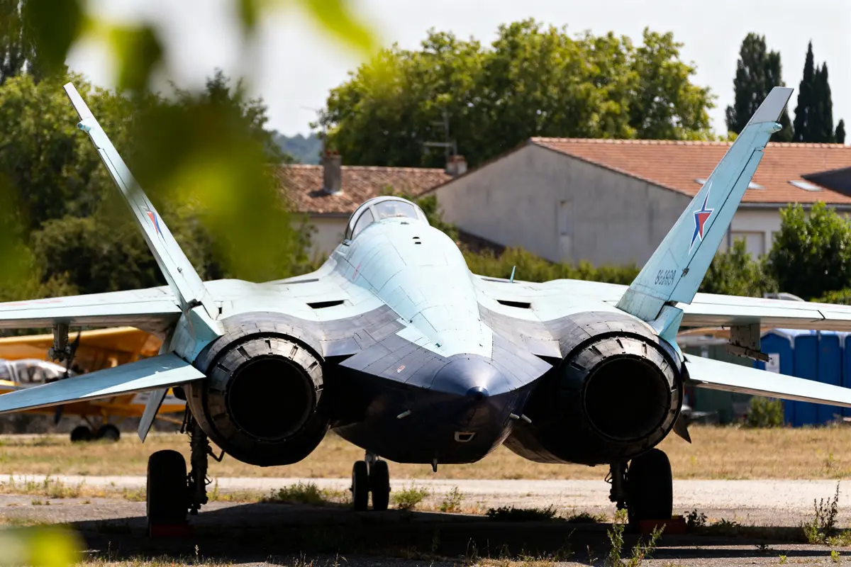 Vue arrière d'un avion de chasse avec la silhouette caractéristique du Su-47.